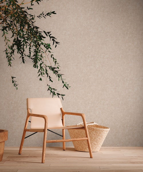 Innenraum mit einem Sessel aus Holz und einer Dekoration an der Wand