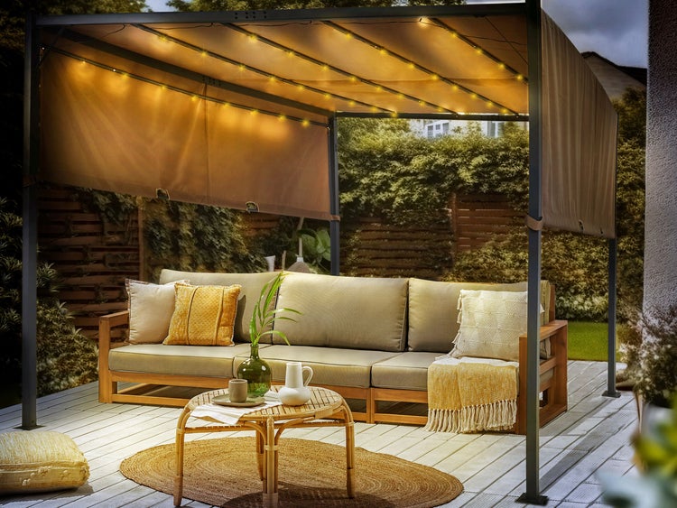 Moderne Pergola mit integrierter LED-Beleuchtung und ausziehbaren Seitenteilen über einem hölzernen Outdoor-Sofa auf einer Terrasse.