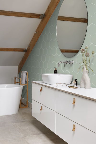 Badezimmer mit Waschbecken, Spiegel und sechseckigen Wandfliesen