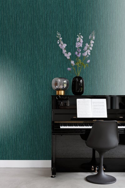 Szene mit schwarzem Klavier, Stuhl, Tischlampe und einer Vase mit Blumen vor einer strukturierten Tapete