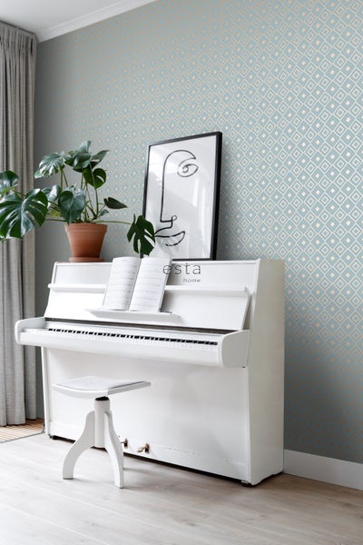 Wohnraum mit gemusterter Tapete, weißem Klavier, Zimmerpflanze und gerahmtem Kunstdruck
