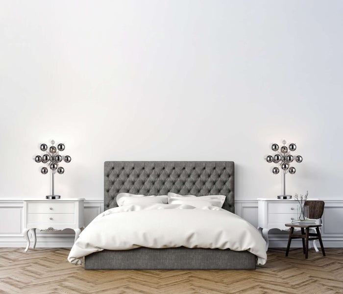 Schlafzimmer mit Bett, Nachttischen und Lampen