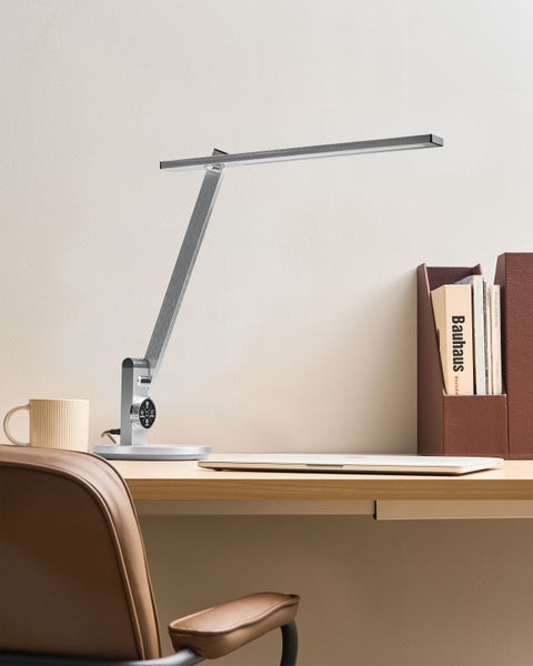 Schreibtisch mit Schreibtischleuchte, Tasse, Laptop und Aktenablage