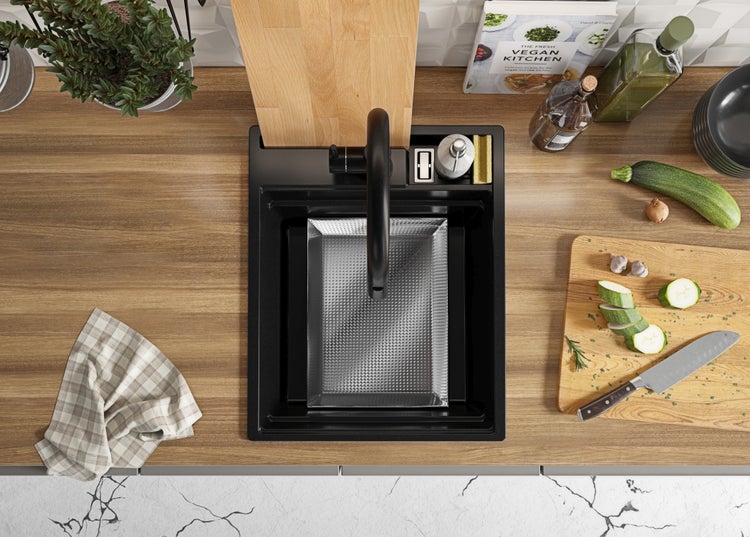 Küchenszene mit Spüle, Schneidebrett und Kochutensilien auf einer Holzoberfläche