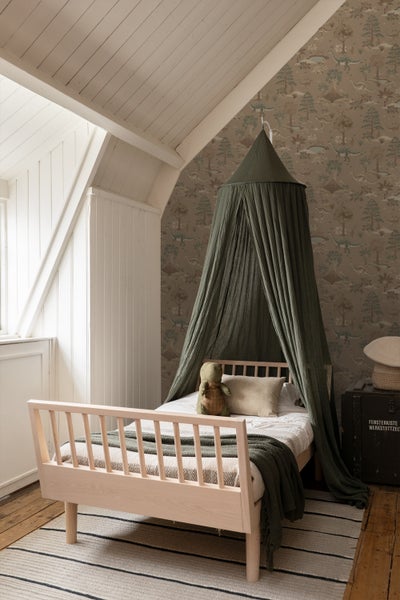 Kinderzimmer mit Holzbett und Dinosaurier-Tapete