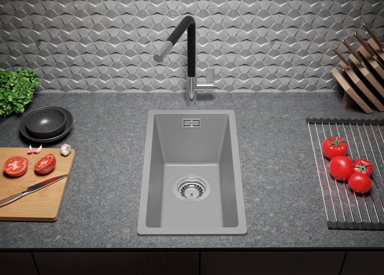 Küchenspüle mit Wasserhahn, Schneidebrett, Geschirr und Lebensmitteln auf einer Arbeitsplatte