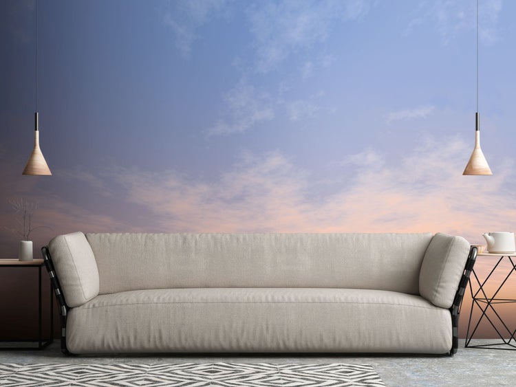 Wohnzimmer mit Stoffsofa, Teppich mit geometrischem Muster und zwei Beistelltischen mit Lampen