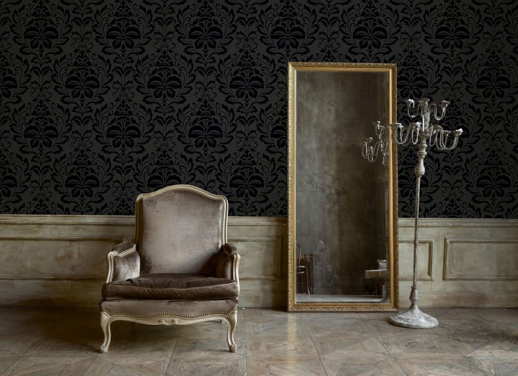 Wohnzimmer mit gemusterter Tapete, Sofa, Kronleuchter und dekorativen Elementen für eine stilvolle Inneneinrichtung.