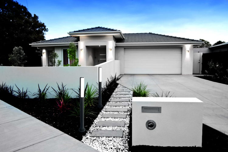 Moderne Hausfassade mit Gartenweg und Beleuchtung