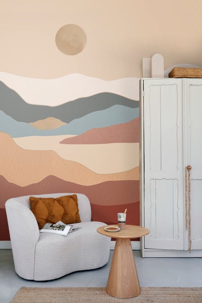 Wohnzimmer mit Sessel, Tisch, Schrank und dekorativer Wandgestaltung