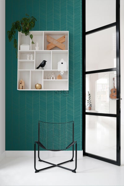 Raumansicht mit gemusterter Tapete, Regal, Stuhl und Glastür