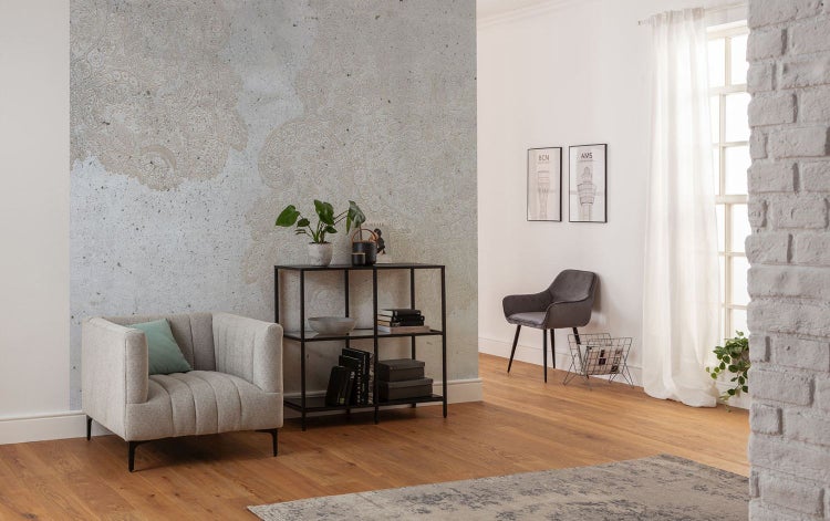 Wohnzimmer mit Sessel, Regal und dekorativer Wand