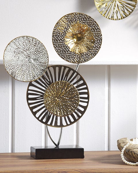 Dekorative Metallskulptur mit kreisförmigen Elementen auf einem Holzregal