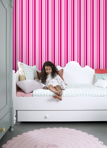 Kinderzimmer mit gestreifter Tapete, weißem Bett und Mädchen