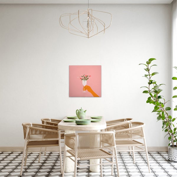 Esszimmer mit Esstisch, Stühlen, Zimmerpflanze, Lampe und einem Bild mit einer Hand, die ein mit Blumen gefülltes Glas hält.