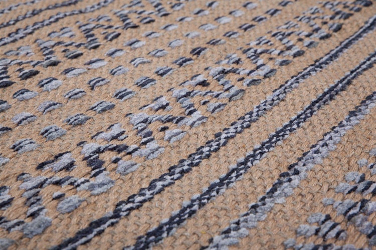 Nahaufnahme eines gewebten Teppichs mit geometrischem Muster und Streifen.
