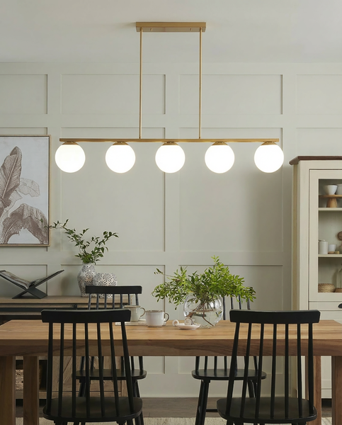 Pendelleuchte mit fünf runden Glaskugeln über einem Esstisch