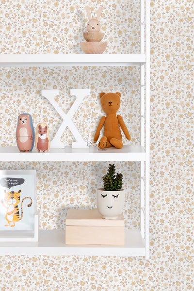 Dekoratives Regal mit Spielsachen und Dekoration vor einer geblümten Tapete
