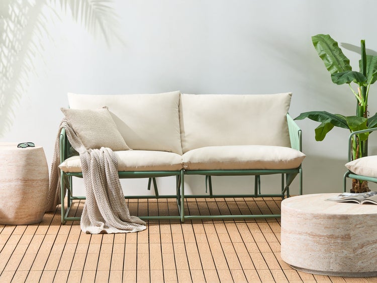 Gartenlounge mit Polstern, Decke und Beistelltischen auf einer Holzterrasse