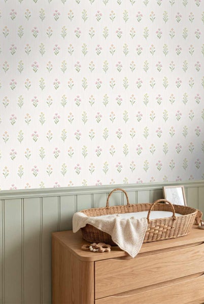 Vliestapete mit floralem Muster und vertikalen Streifen über einer hellgrünen Wandvertäfelung aus Holz in einem Kinderzimmer.