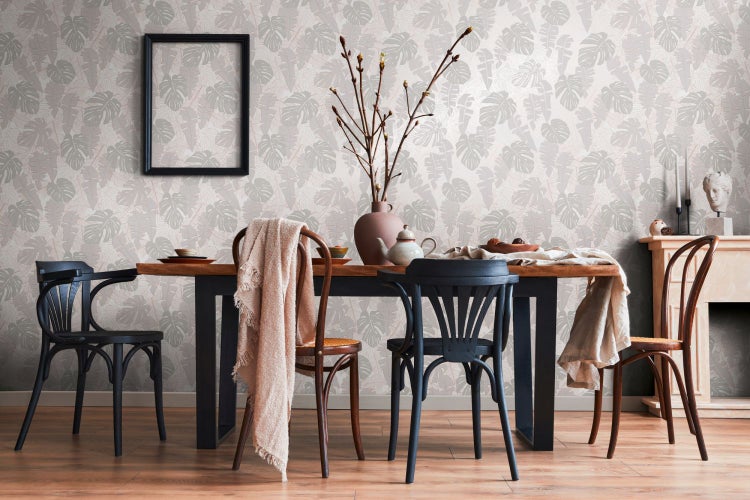 Szene mit einer schwarzen Ottomane mit Stauraum, einer Dekoration und einer Decke in einem hellen Raum.