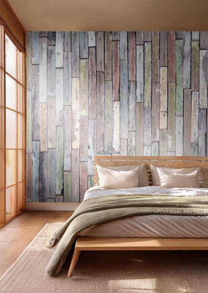 Ein Schlafzimmer mit einer Wandtapete in Holzoptik hinter einem Holzbett