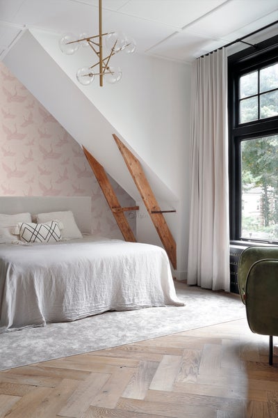 Schlafzimmer mit Bett, Vorhängen und Dachschrägen