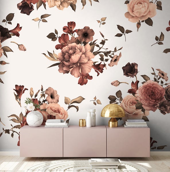 Vliestapete mit großflächigem, vintage-inspiriertem Blumenmuster in Rosa- und Brauntönen hinter einem modernen Sideboard im Wohnzimmer.