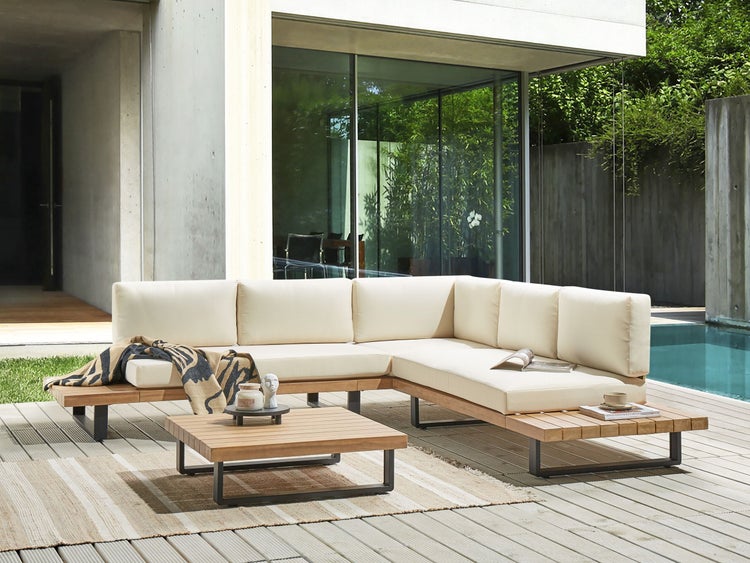 Gartensitzgruppe mit L-förmigem Sofa, Tisch und Dekoration auf einer Terrasse