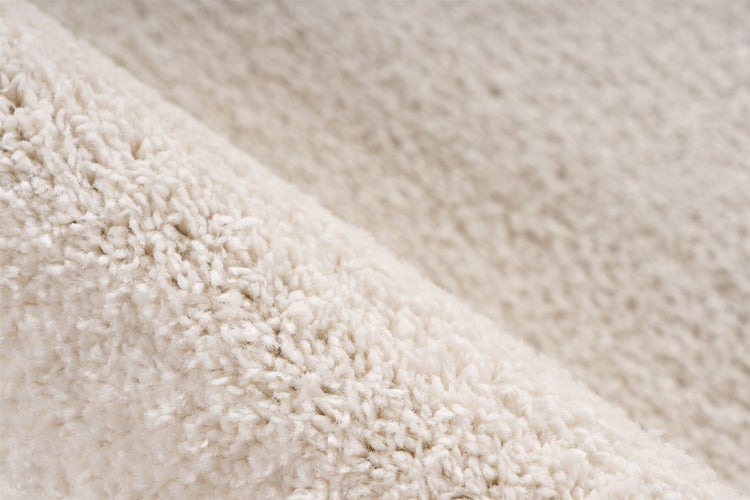 Nahaufnahme der Textur eines hochflorigen Teppichs.