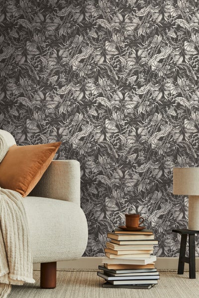 Dekoratives Einmachglas mit Tannenzapfen, Beeren und Lichterkette, aufgehängt an einem Baum.