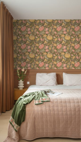 Schlafzimmer mit gemusterter Tapete, Bett, Vorhängen und Nachttisch