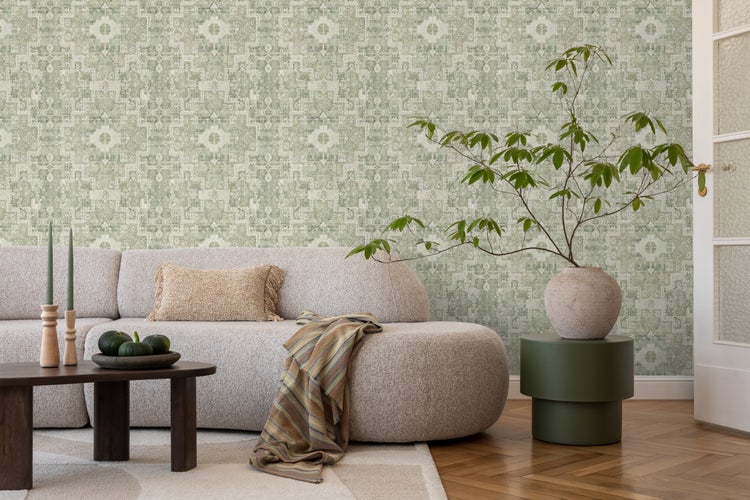 Wohnzimmer mit gemusterter Tapete, Sofa, Couchtisch und Zimmerpflanze