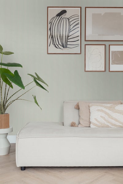 Wohnzimmer mit gestreifter Tapete, Sofa und Dekorationen