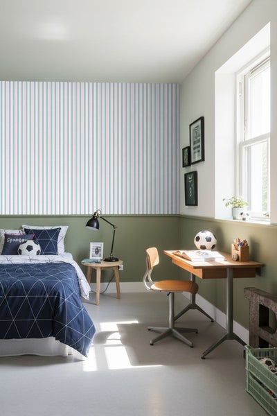 Ein Kinderzimmer mit Bett, Schreibtisch und gestreifter Tapete.