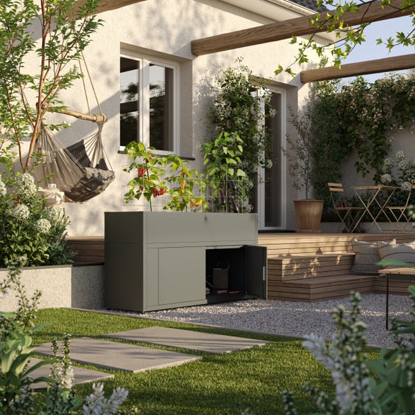 Modernes Hochbeet aus grauem Metall mit integriertem Unterschrank auf einer sonnigen Terrasse mit Pflanzen und Holzpergola.