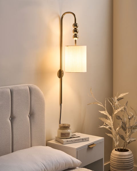 Wandleuchte über einem Nachttisch im Schlafzimmer.