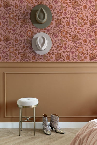 Wandgestaltung mit floral gemusterter Tapete im oberen Bereich und dekorativen Wandleisten im unteren Bereich inklusive Hocker und Accessoires.