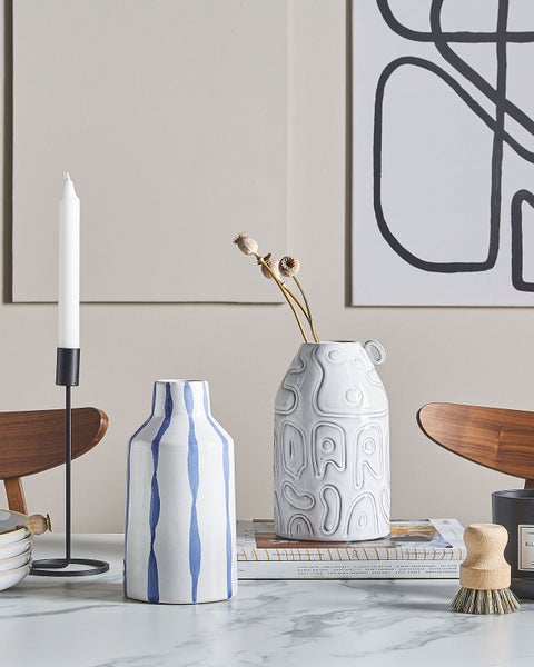 Dekoratives Arrangement mit Vasen, Kerzenständer, Bürste und abstraktem Wandbild