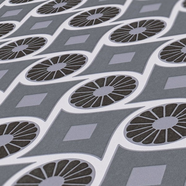 Raumansicht mit gemusterter Tapete, gerahmtem Bild und Teegeschirr