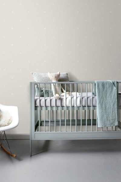 Kinderzimmer mit blauem Gitterbett, Spielzeug und maritim gemusterter Tapete
