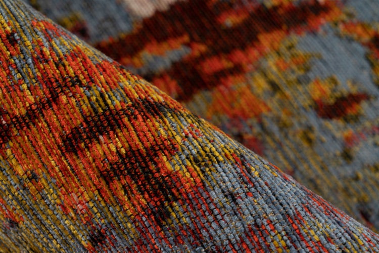 Nahaufnahme eines Teppichs mit buntem, abstraktem Muster und strukturierter Oberfläche.