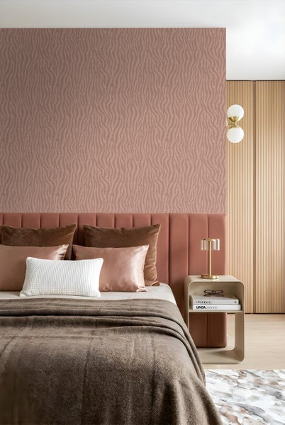 Modernes Schlafzimmer mit Vliestapete mit Wellenmuster hinter einem gepolsterten Kopfteil und einem Nachttisch mit Tischleuchte.