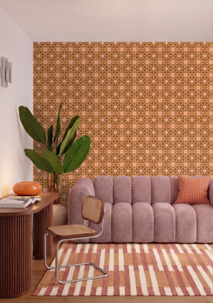 Schlafzimmer mit Vliestapete im Retro-Design, Bett mit Kissen und Decken, große Zimmerpflanze im Topf.