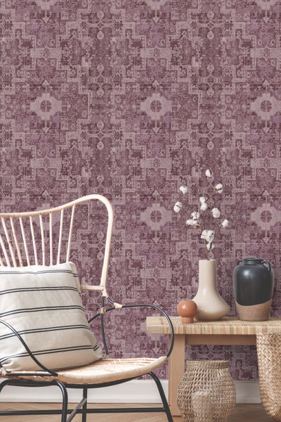 Eine Person hält ein Smartphone mit einer App zur Visualisierung von Tapeten in einem Raum.