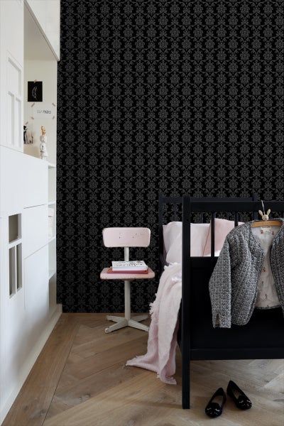 Kinderzimmer mit gemusterter Tapete, Bett und Schreibtischstuhl