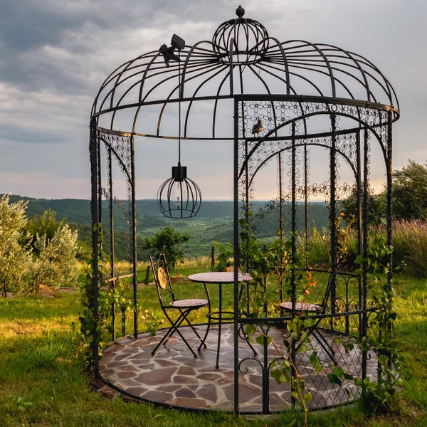 Metallpavillon mit Tisch und Stühlen im Garten