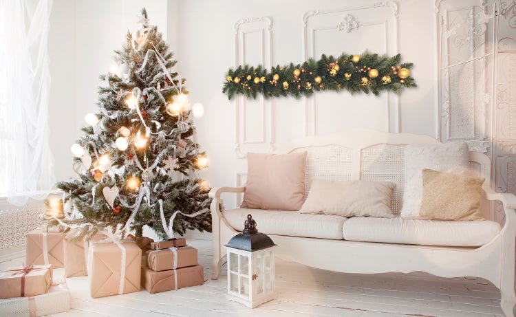 Weihnachtliche Wohnzimmerdekoration mit Tannenbaum, Geschenken, Lichterketten und Girlande