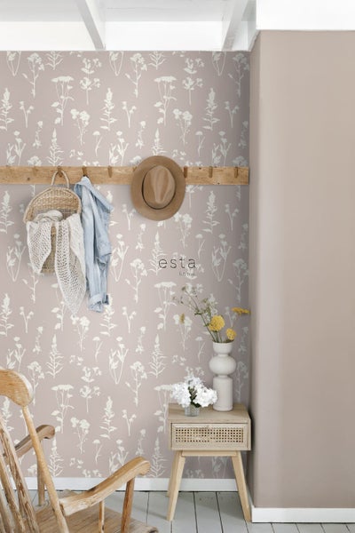 Raumansicht mit Blumentapete, Holzhocker und dekorativen Elementen für ein gemütliches Ambiente