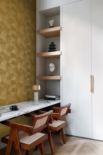 Schlafzimmer mit geometrischer Tapete, Nachttisch und Lampe